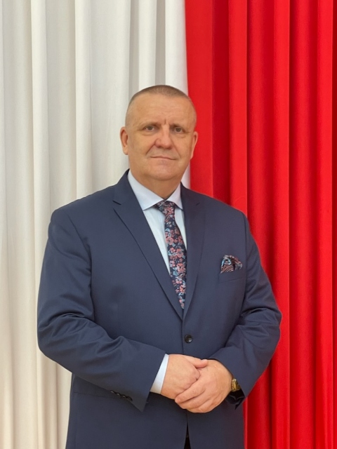 Zdjęcie przedstawiające Burmistrza Miasta i Gminy w Kunowie na tle biało-czerwonej  flagi